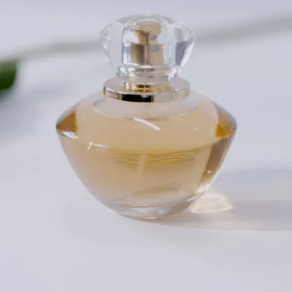 Original photo: glass perfume bottle on a white table
