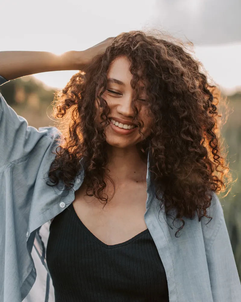 Original photo: woman with curly hair smiling outdoors
